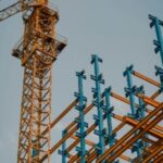 A crane and some blue scaffolding on top of a building.